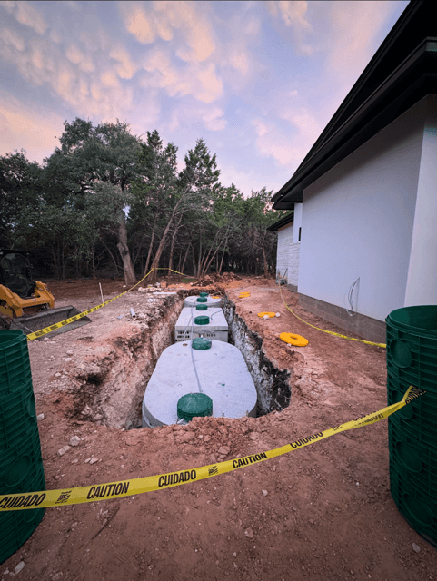 Septic installation materials staged beside a home at dusk